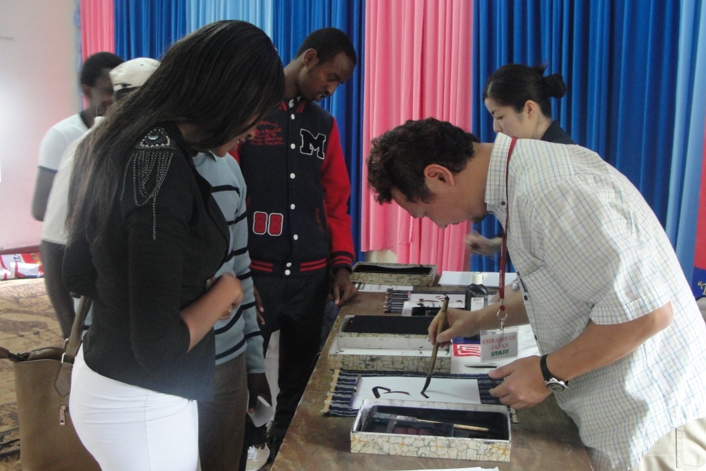 Ms. Nakuru (front left) getting her name written in Japanese calligraphy