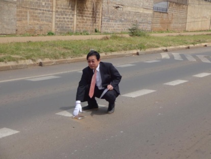 道路鋲(キャッツ・アイ)の説明をするJICA専門家
