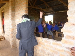 H.E. Mr. Terada greeting and sitting in the humble classroom with pupils