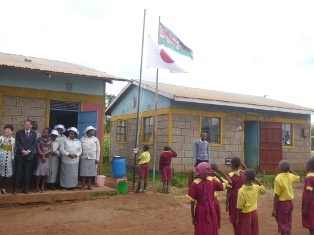 Pupils hoisting the national flags of Kenya and Japan