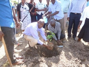 Mr. Erick Dudi, Director of Arise & Shine Care Center  planting a tree