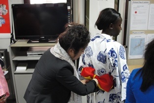 A member of the audience being assisted to wear a yukata