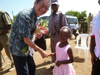 H.E. Mr. Tatsushi Terada welcomed by a girl in the community
