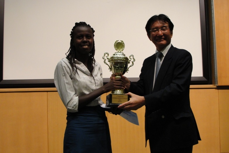 Ms. Ruth Gathoni Mwaniki, winner of the 9th Japanese Language Speech Contest receiving a prize from one of the sponsors from Marubeni Corporation