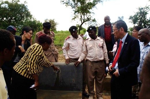 Ambassador Terada receiving explanation about the water tap which is piped from the dam
