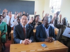 Mr. Mori, Charge d’ Affaires of Japanese Embassy in the Republic of Kenya and Mr. Cornelius Serem, Member of Parliament of Aldai Constituency celebrating completion of classroom with pupils.
