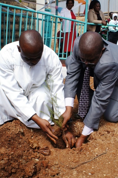 Father Regilio Kirimi, Representative of the Bishop, planting a tree to commemorate the occasion
