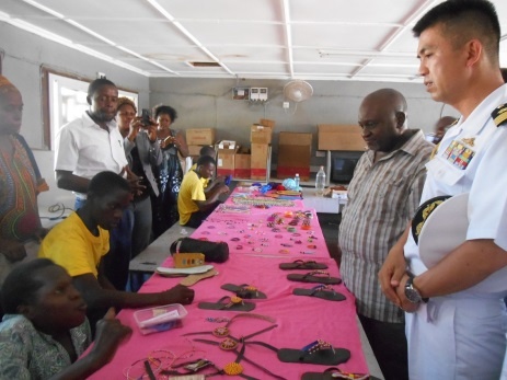 Representative from the Embassy of Japan receiving explanation about the products made by the students