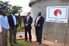 Organization representative explains about the project in front of the water tank